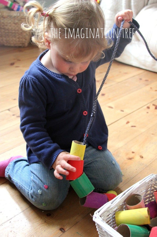 Toddler threading activity with giant cardboard beads